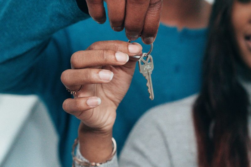 Home 16 A couple joyfully holds a key, symbolizing their new home ownership.
